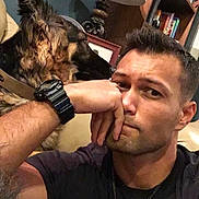 Max is registered to the contest to win money with this photo: bookcase, brown_dog, collar, couch, decor, dog, expression, face, furniture, home, indoor, man, portrait, relaxed, resting, shelf, short_hair, sitting, watch, watchband