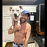 Stormy joined the competition — help win amazing prizes! blue_cap, cabinets, chair, countertop, dog, happy, home, indoor, kitchen, man, person, pet, piggyback, plaid_shorts, portrait, puppy, refrigerator, shirtless, smiling, white_dog