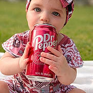 Adaline is registered to the contest to win money with this photo: baby, child, headband, bow, drink, can, sitting, outdoor, grass, blanket, cute, portrait, clothing, red, white, person, hands, face, eyes, bottle