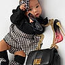 Ashley is registered to the contest to win money with this photo: baby, infant, black_and_white, houndstooth, headband, socks, sunglasses, handbag, perfume_bottle, high_heel, fashion, accessories, cute, portrait, studio, white_background, child, lying_down, person, stylish
