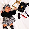 Ashley is registered to the contest to win money with this photo: baby, infant, child, black_clothing, houndstooth_pattern, headband, makeup_brush, purse, handbag, sunglasses, lipstick, mascara, high_heel_shoe, white_blanket, milestone_sign, 2_months, fashion, accessories, portrait, cute