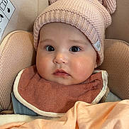 Sophia a rejoint le concours — aidez-le/la à gagner de superbes lots ! baby, child, infant, knitted_hat, bear_ears, bib, blanket, car_seat, face, eyes, cute, soft, warm, indoors, portrait, cozy, clothing, child_seat, expression, adorable