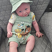 Theo is registered to the contest to win money with this photo: baby, child, hat, green_clothing, lion_king, smile, sitting, chair, quilted, cute, infant, happy, portrait, face, legs, feet, shorts, toddler, indoors, clothing