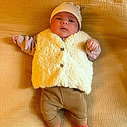 Flavia a rejoint le concours — aidez-le/la à gagner de superbes lots ! baby, infant, hat, vest, socks, blanket, lying_down, cute, warm_clothing, cozy, child, portrait, face, small_hands, red_socks, neutral_background, soft_texture, indoors, comfortable, newborn