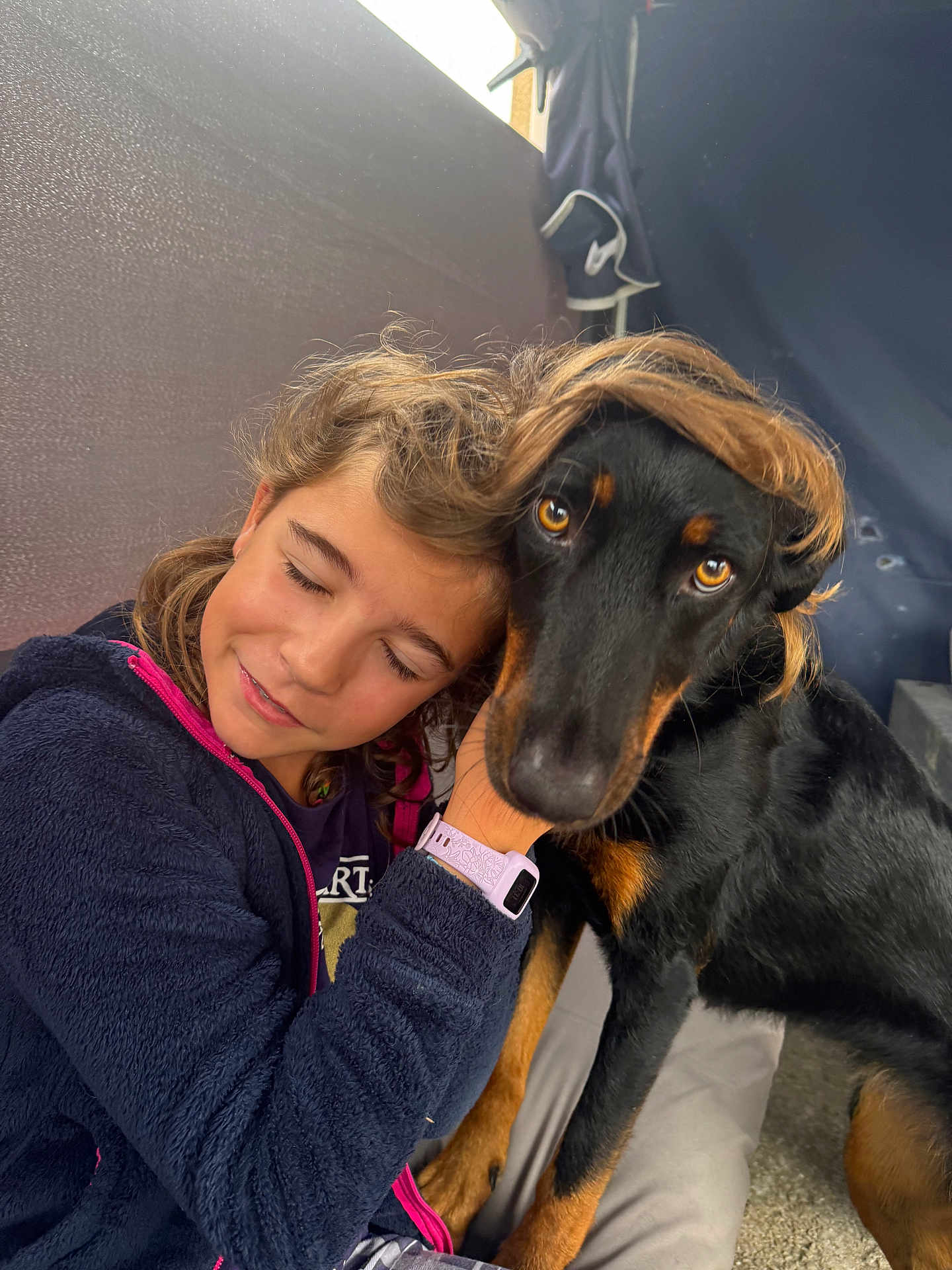Trann a rejoint le concours — aidez-le/la à gagner de superbes lots ! child, dog, hug, affection, indoor, black_dog, brown_markings, hair, smile, closed_eyes, watching, friendship, cute, pet, furry, portrait, cuddle, jacket, watch, floor