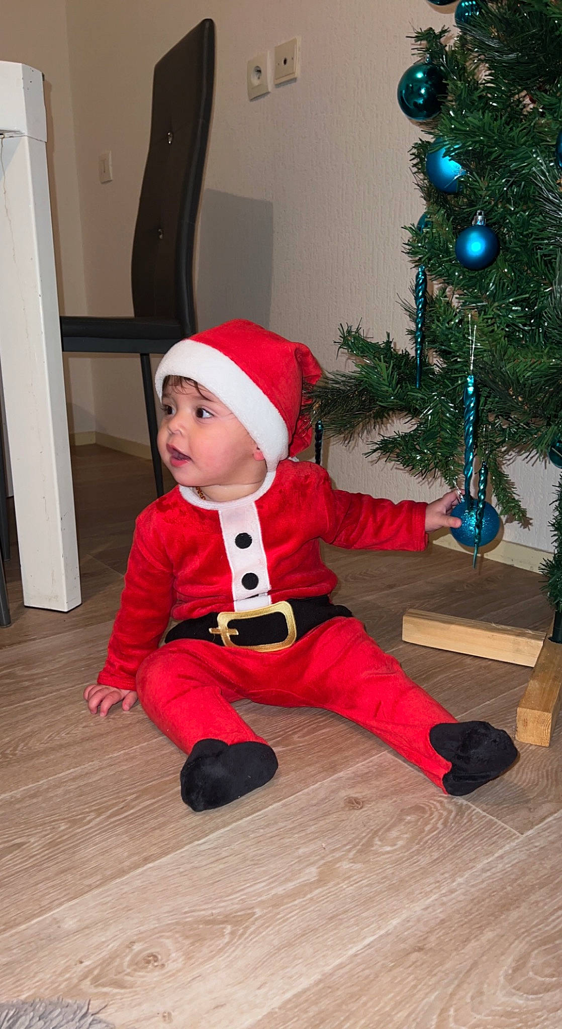 Julio participe au concours pour gagner de l'argent avec cette photo : baby, baby_toddler_clothing, carmine, christmas_decoration, christmas_ornament, christmas_tree, event, evergreen, flooring, hardwood, hat, headwear, holiday, holiday_ornament, ornament, person, plant, sleeve, toddler, tree