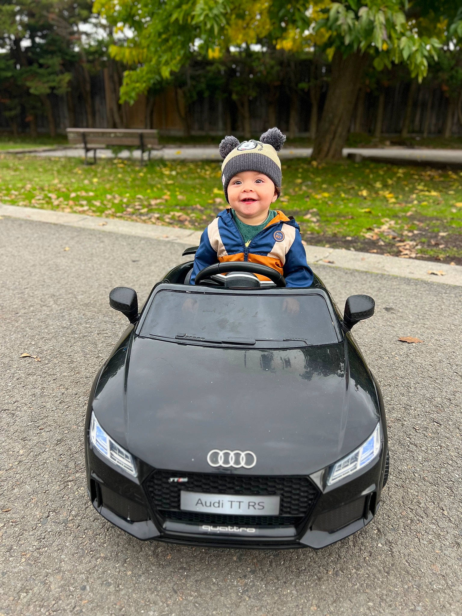 Julio a rejoint le concours — aidez-le/la à gagner de superbes lots ! asphalt, automotive_design, automotive_exterior, automotive_lighting, automotive_mirror, automotive_wheel_system, bumper, car, grille, headlamp, headwear, hood, joy, motor_vehicle, performance_car, person, personal_luxury_car, plant, toddler, tree