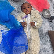 Rayyan joined the competition — help win amazing prizes! baby, child, onesie, fluffy_clothing, striped_socks, metal_bowls, sheer_fabric, blue_fabric, red_fabric, shaggy_rug, floor, indoor, curious_expression, laying_down, infant, soft_texture, cozy, cute, person, portrait