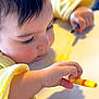 Antoinette is registered to the contest to win money with this photo: toddler, child, yellow_sweater, drawing, marker, close_up, face, hand, concentration, art, creativity, indoor, skin, eyelashes, table, writing_instrument, young_child, expression, casual_clothing, activity