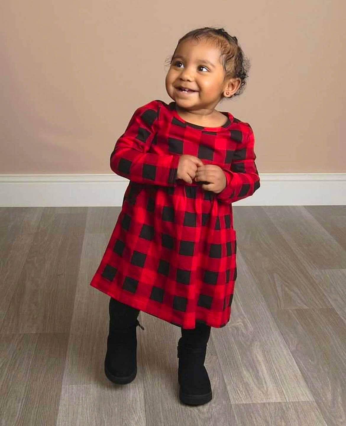 Iyanna joined the competition — help win amazing prizes! baby_toddler_clothing, collar, dress, dress_shirt, event, face, floor, flooring, human_leg, joy, knee, neck, one_piece_garment, pattern, person, plaid, sitting, sleeve, smile, tartan