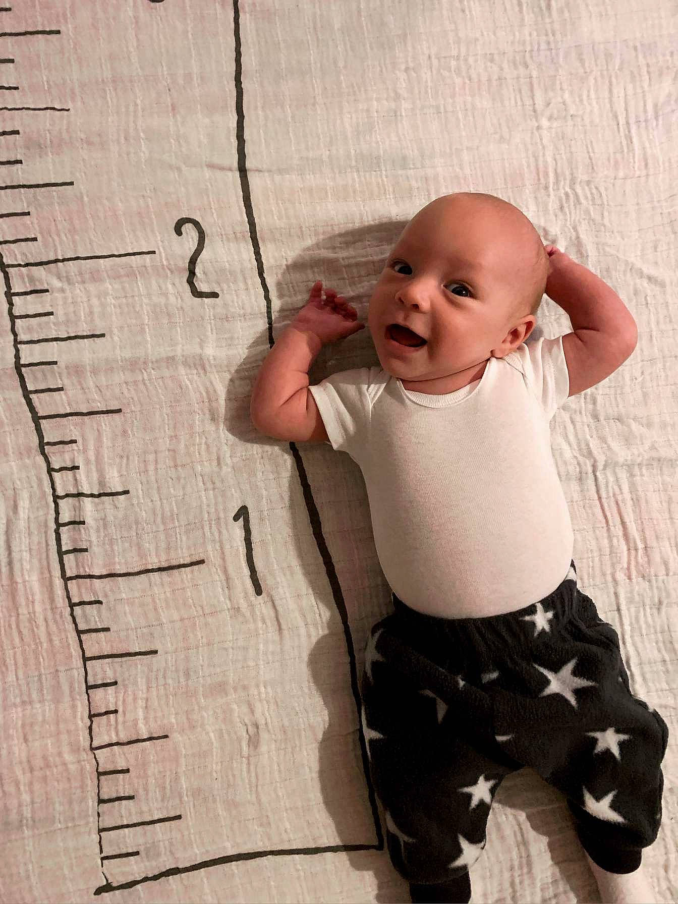 Eric is registered to the contest to win money with this photo: arm, baby, baby_toddler_clothing, beauty, child, elbow, flooring, fun, gesture, happy, head, joint, monochrome, monochrome_photography, pattern, person, shorts, sleeve, smile, t_shirt
