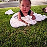 baby, child, infant, grass, outdoor, blanket, star_pattern, lying_down, portrait, face, curious, eyes, black_hair, park, lawn, street, gas_station, daylight, photography, safe