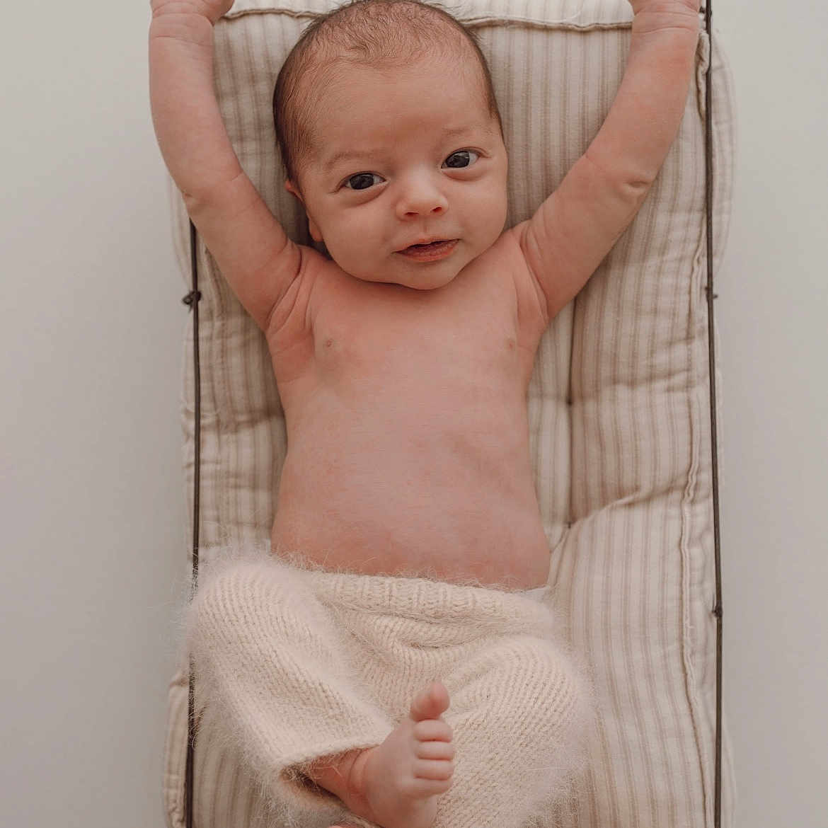 Timéo participe au concours pour gagner de l'argent avec cette photo : baby, infant, newborn, wire_basket, cushion, stretching, arms_up, fuzzy_pants, neutral_colors, portrait, soft_lighting, cozy, relaxed, cute, bare_chest, small_feet, indoors, sleepwear, resting, child