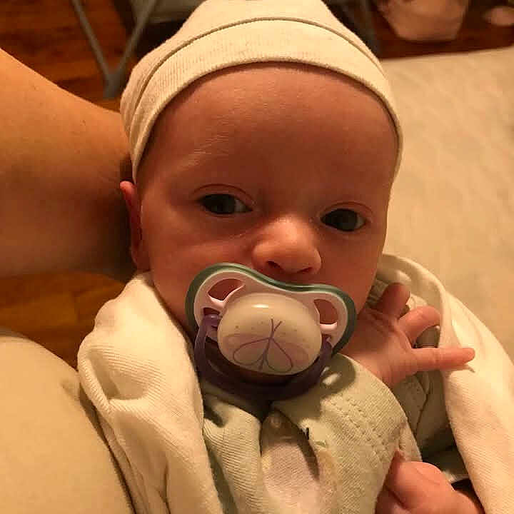 Skylah joined the competition — help win amazing prizes! baby, bedroom, blanket, clothing, comfort, curious, face, furniture, hand, headwear, holding, indoor, infant, newborn, pacifier, person, rest, skin, soft_light, warmth