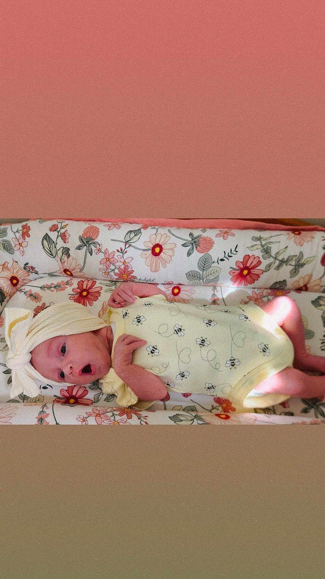 Skylah joined the competition — help win amazing prizes! baby, infant, newborn, yellow_outfit, head_wrap, floral_pattern, cushion, lying_down, surprised_expression, soft_light, indoors, cute, small_hands, small_feet, person, child, face, sleeping_bed, comfort, resting