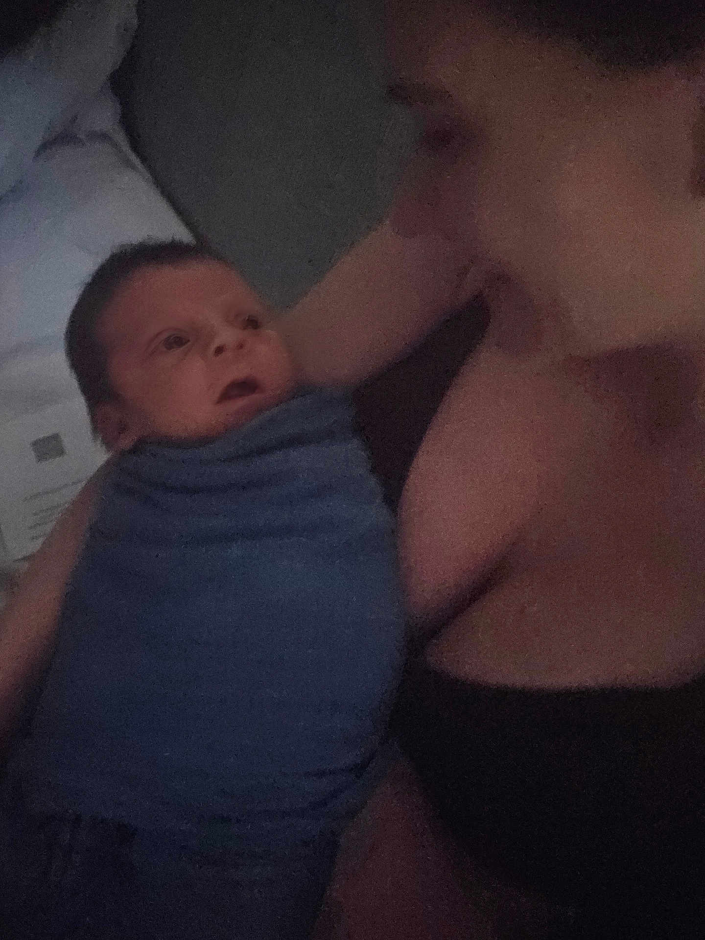 Crew is registered to the contest to win money with this photo: baby, infant, adult, person, blanket, blue_blanket, indoor, low_light, grainy, portrait, closeup, face, skin, expression, holding, cuddle, love, family, tender, quiet