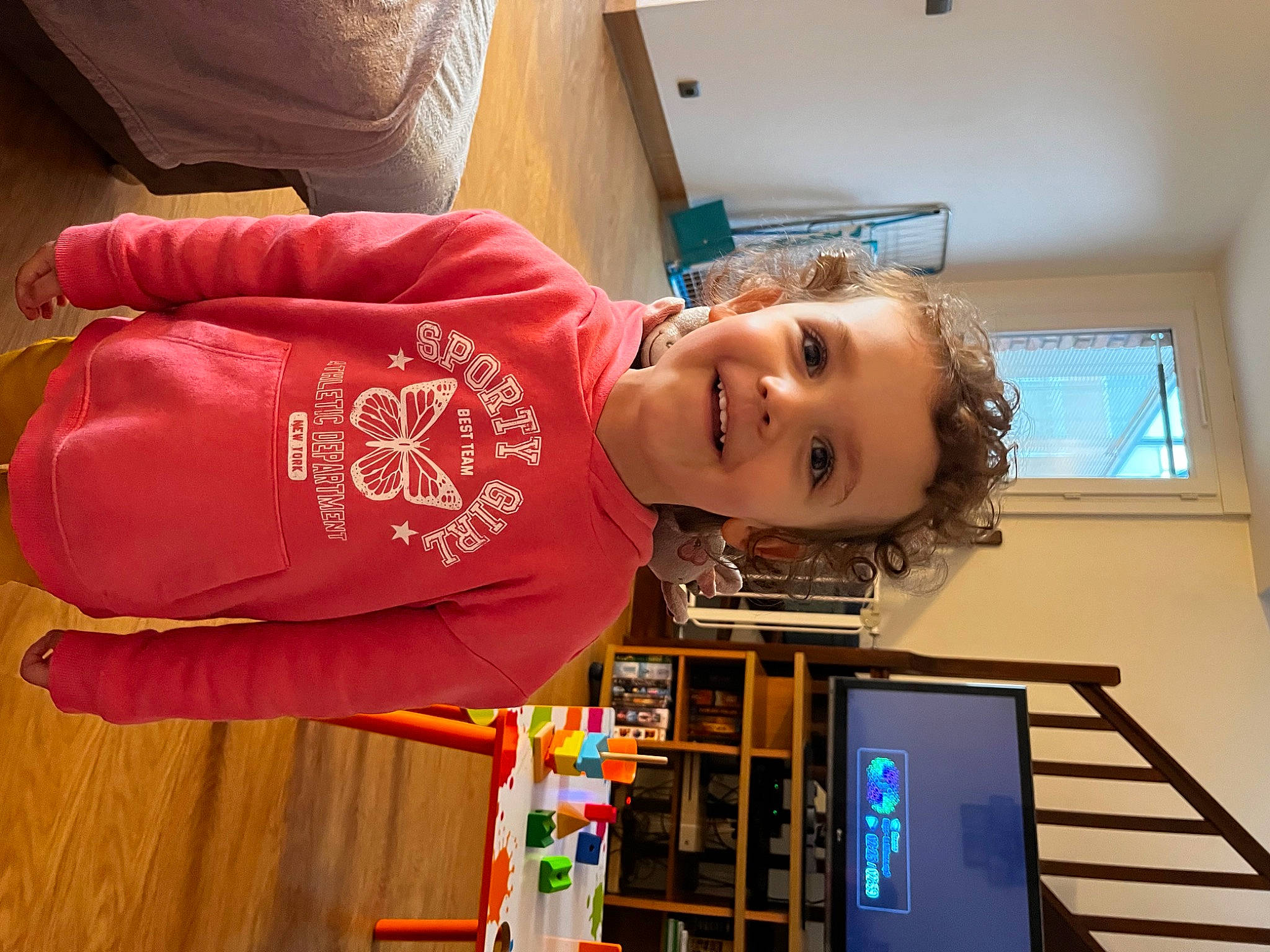 Roxane a rejoint le concours — aidez-le/la à gagner de superbes lots ! bookcase, child, flooring, fun, happy, hardwood, house, joy, machine, person, room, sleeve, smile, t_shirt, toddler, window, wood