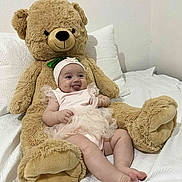 Juliana is registered to the contest to win money with this photo: baby, bed, child, comfortable, cuddly, cute, happy, headband, indoor, infant, pink_outfit, playful, plush_toy, resting, smiling, soft, teddy_bear, tongue_out, toy, white_bedspread