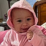 Isabella is registered to the contest to win money with this photo: baby, child, hoodie, pink_clothing, smiling, indoor, bedroom, person, cute, portrait, happy, face, hand, furniture, wood, calendar, cozy, infant, playful, young
