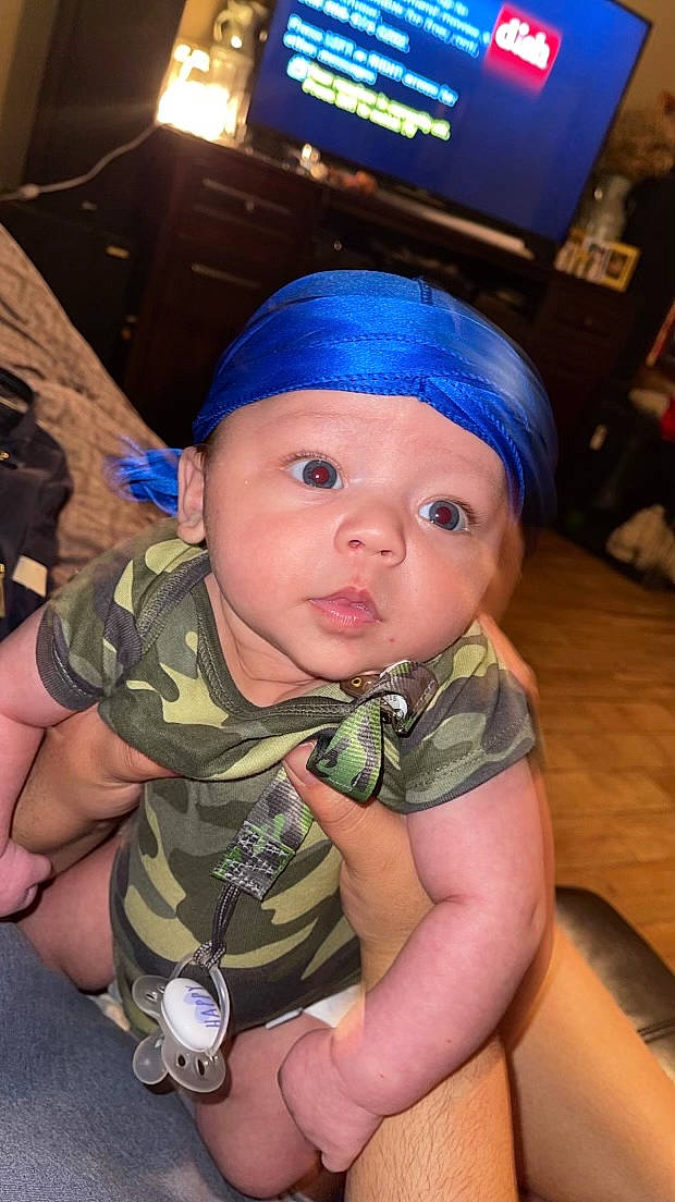 Josiah joined the competition — help win amazing prizes! baby, baby_toddler_clothing, camouflage, cap, car_seat, child, fashion_accessory, fun, gesture, hat, headwear, military_camouflage, pattern, person, personal_protective_equipment, sitting, television, thumb, toddler