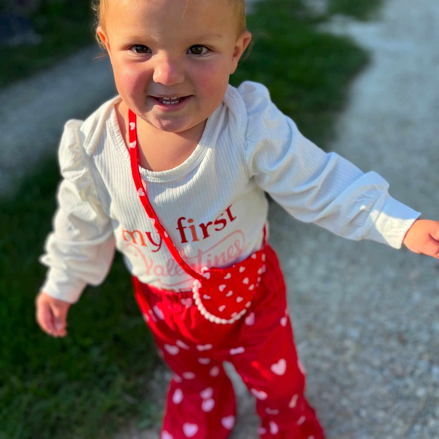 Hesmé participe au concours pour gagner de l'argent avec cette photo : baby, bodypart, city, clothing, dress, face, finger, grass, hand, happy, head, pajamas, pants, person, photography, plant, portrait, road, street, urban