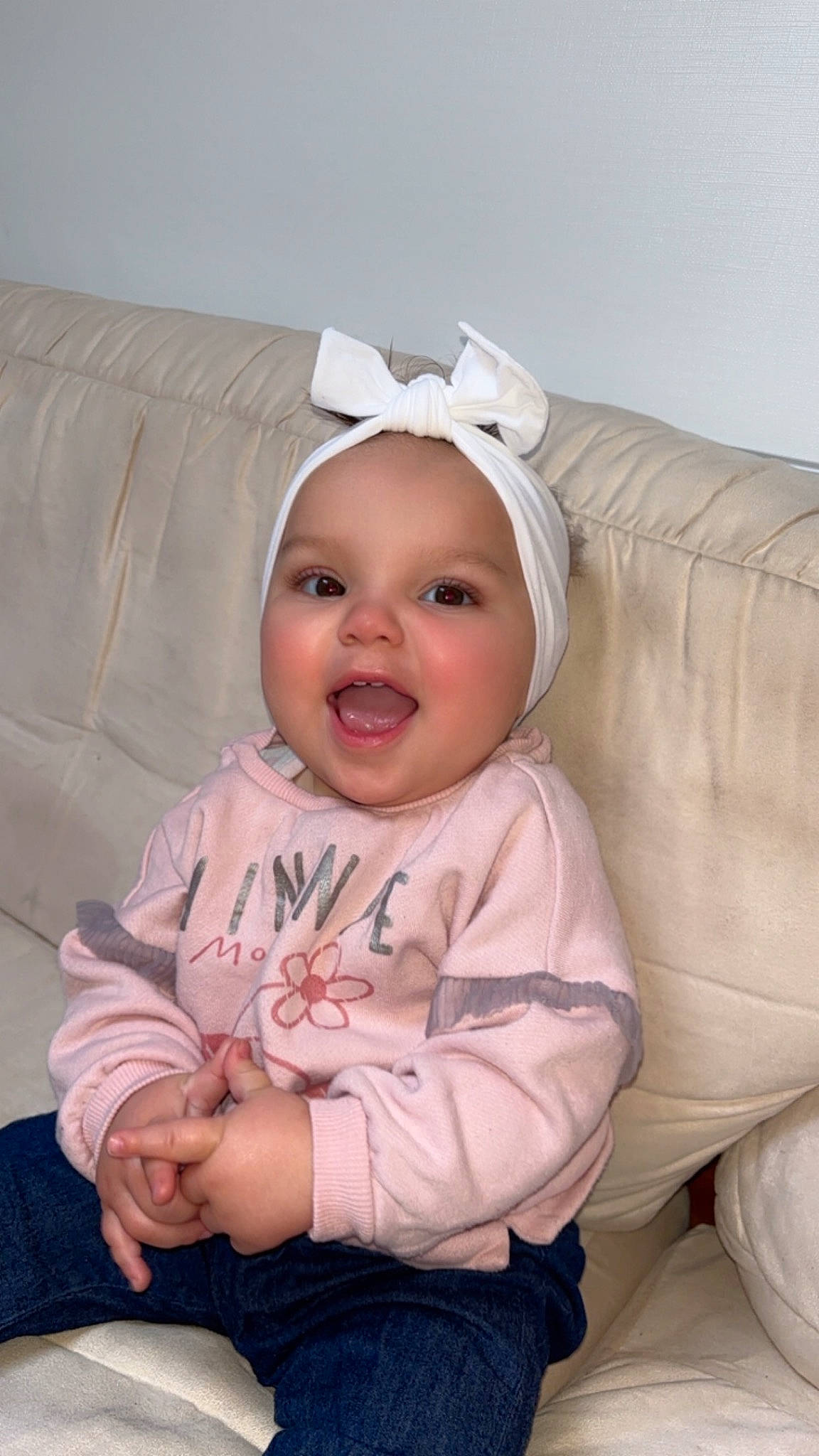 Hesmé participe au concours pour gagner de l'argent avec cette photo : baby, baby_laughing, baby_toddler_clothing, cheek, child, comfort, couch, eye, face, happy, head, headwear, iris, linens, lip, person, pink, sitting, skin, sleeve