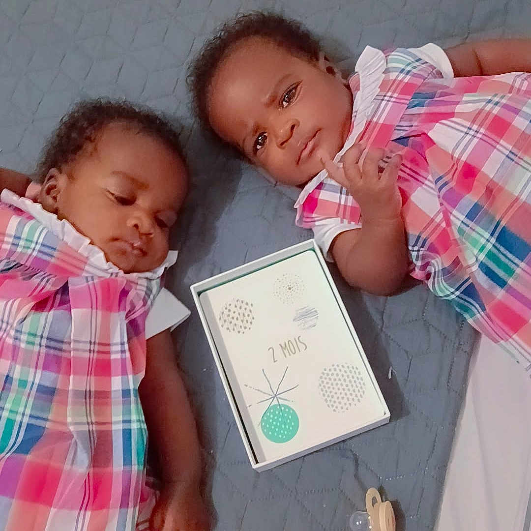 Naomie Et Naelle participe au concours pour gagner de l'argent avec cette photo : baby, blanket, card, child, cute, face, hair, indoor, infant, lying_down, milestone, pacifier, person, pink, plaid_dress, resting, skin, sleepy, toddler, toy