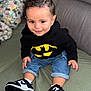 Raphaël a rejoint le concours — aidez-le/la à gagner de superbes lots ! toddler, child, batman_hoodie, sneakers, jeans, couch, blanket, indoor, smiling, cute, fashion, casual_wear, portrait, happy, seated, young_child, person, clothing, footwear, hair