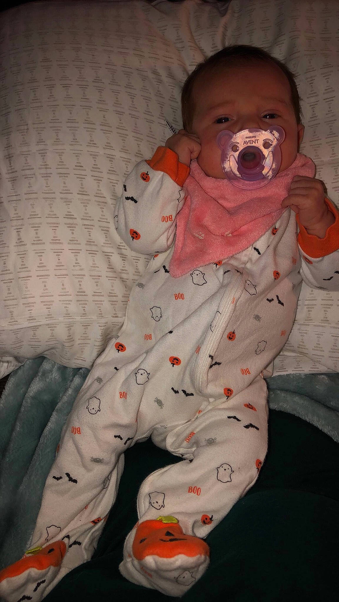 Enid is registered to the contest to win money with this photo: arm, baby, baby_products, baby_toddler_clothing, child, comfort, entertainment, face, finger, hand, head, human_body, mouth, nose, orange, person, pink, plant, skin, sleeve