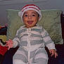 baby, bed, celebration, child, christmas, cute, happy, hat, holiday, indoor, infant, pajamas, person, pillow, portrait, sitting, smiling, socks, striped, young