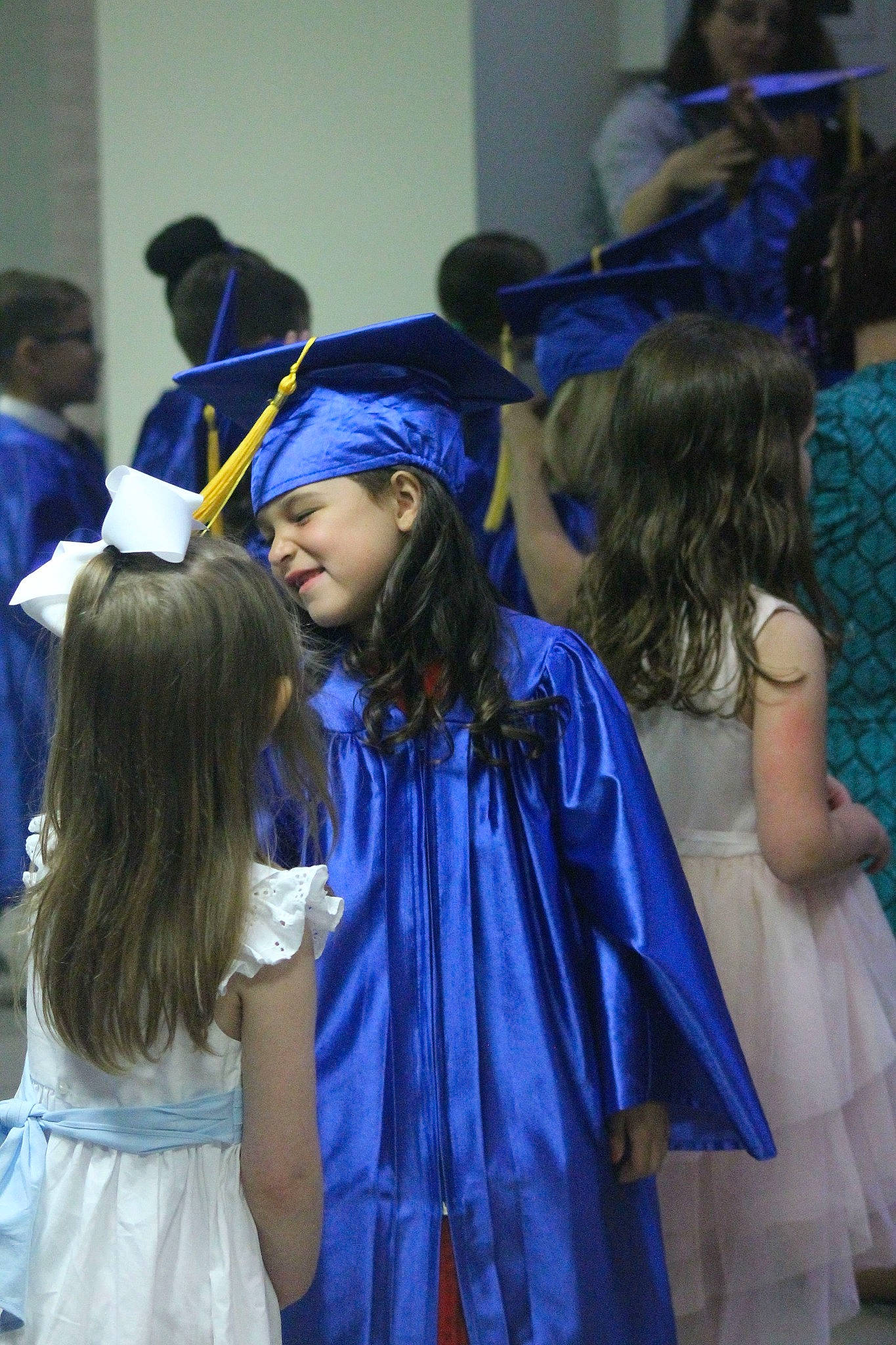 Mavis is registered to the contest to win money with this photo: academic_institution, blue, clothing, electric_blue, event, fashion_design, formal_wear, fun, hairstyle, hat, headgear, headwear, interaction, long_hair, mortarboard, person, purple, scholar, smile, social_group