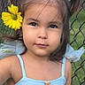 child, girl, portrait, flower, hair_bow, twin_ponytails, blue_dress, outdoor, fence, grass, cute, smiling, young, face, person, summer, nature, yellow_flower, fashion, innocence