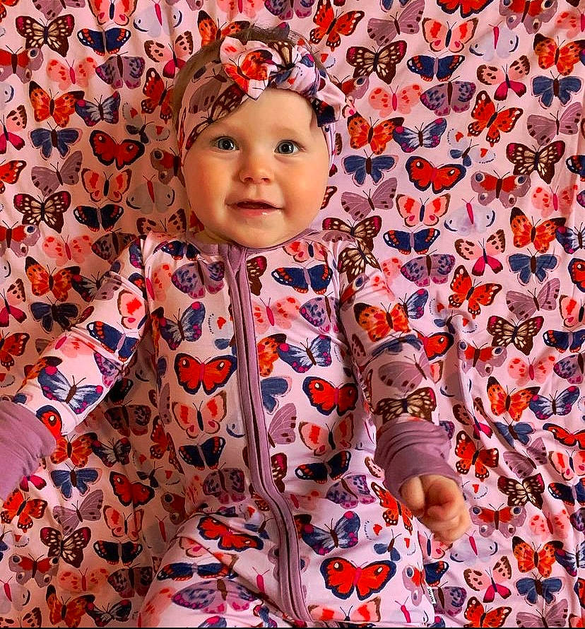 Amara joined the competition — help win amazing prizes! baby, baby_toddler_clothing, facial_expression, flower, happy, head, headwear, outerwear, pattern, people_in_nature, person, petal, photograph, pink, plant, shirt, skin, sleeve, smile, t_shirt