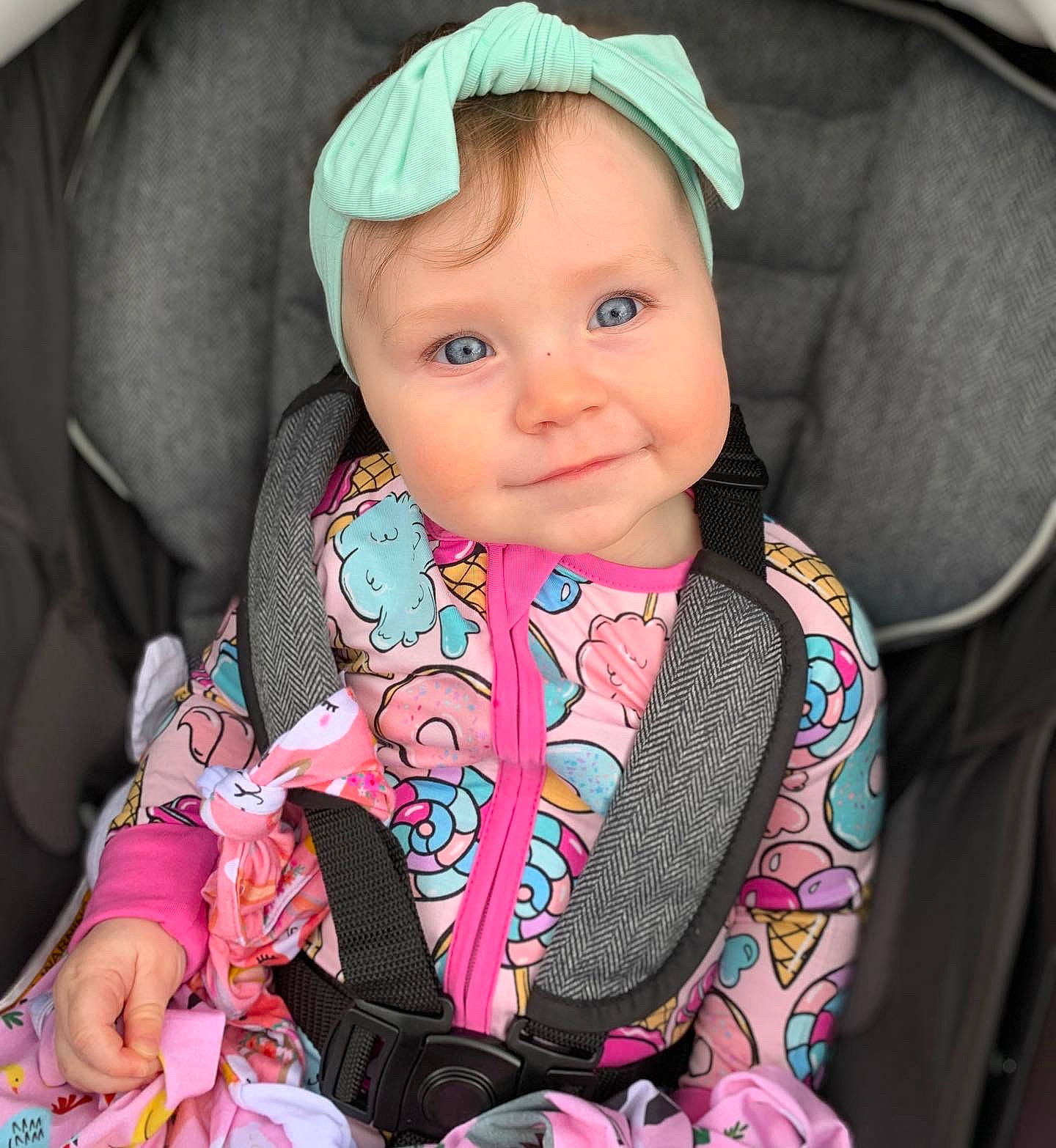 Amara is registered to the contest to win money with this photo: baby, baby_carriage, baby_toddler_clothing, cap, car_seat, cheek, child, cool, eyebrow, face, happy, iris, outerwear, person, pink, seat_belt, skin, sleeve, smile, textile