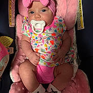 Raylynn joined the competition — help win amazing prizes! baby, bow, child, clothing, colorful, comfortable, cute, footwear, headband, heart_pattern, indoors, infant, newborn, pacifier, person, pink, plush_seat, portrait, sitting, soft_toys