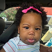 Naela joined the competition — help win amazing prizes! baby, child, infant, portrait, car, car_interior, car_seat, curly_hair, pink_bow, headband, tongue_out, facial_expression, smiling, brown_eyes, earrings, striped_shirt, sitting, indoors, vehicle, closeup