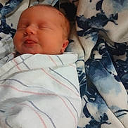Luci is registered to the contest to win money with this photo: baby, newborn, sleeping, blanket, swaddled, infant, cozy, soft, patterned_blanket, face, peaceful, wrapped, child, cute, indoors, resting, portrait, baby_face, comfort, warm