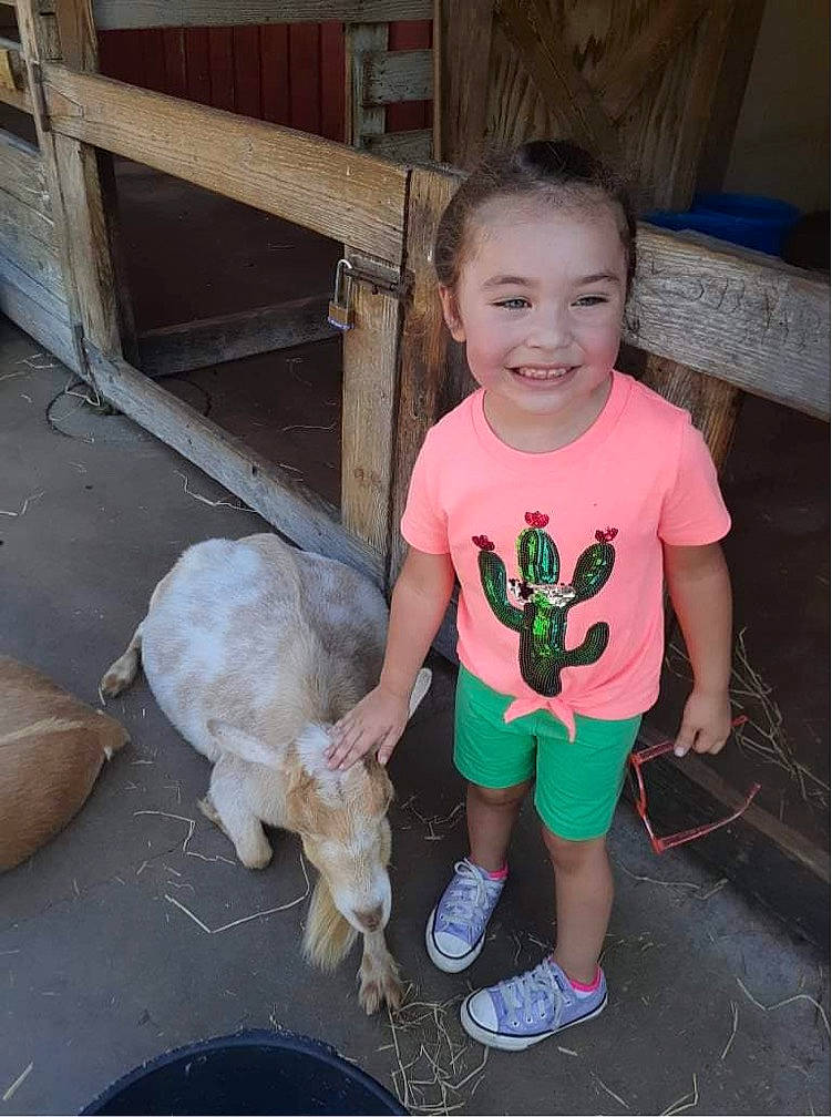 Miami is registered to the contest to win money with this photo: baby_toddler_clothing, child, companion_dog, dog_breed, footwear, fun, grass, happy, human_leg, joy, leg, mammal, person, sandal, shorts, skin, sleeve, smile, t_shirt, tail