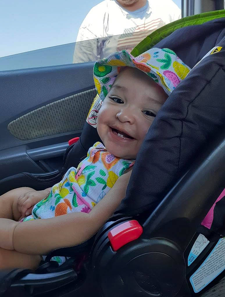 Pennilane is registered to the contest to win money with this photo: auto_part, automotive_design, automotive_exterior, automotive_tire, car, car_seat, car_seat_cover, comfort, grass, hat, headwear, joy, mode_of_transport, motor_vehicle, person, plant, smile, steering_wheel, tire, toddler