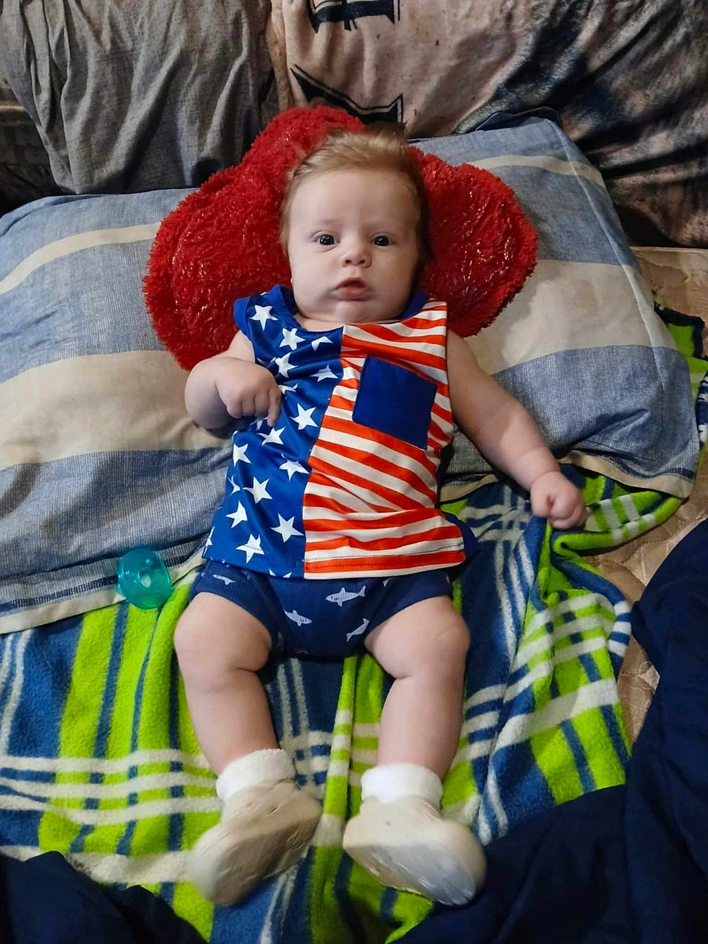 Grayson joined the competition — help win amazing prizes! baby, infant, child, bed, pillow, blanket, clothing, stars, stripes, american_flag, blue, red, white, footwear, pacifier, indoor, person, cute, lying_down, portrait