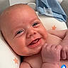 Hudson is registered to the contest to win money with this photo: baby, smiling, infant, face, chubby_cheeks, blue_cloth, cushion, star_pattern, skin, cute, lying_down, indoors, happy, social_media, screenshot, user_interface, comment_section, like_button, portrait, young_child
