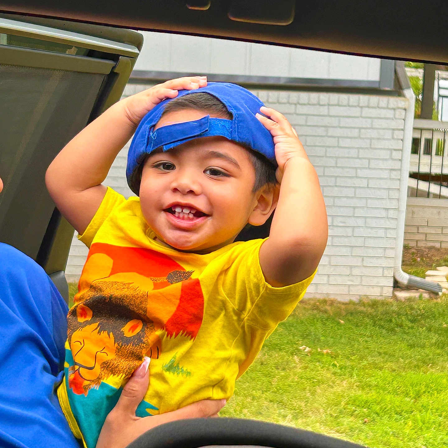 Lionel is registered to the contest to win money with this photo: baby, baseballcap, bodypart, boy, cap, child, clothing, face, finger, grass, hand, hat, head, people, person, photography, plant, portrait, summer, t_shirt