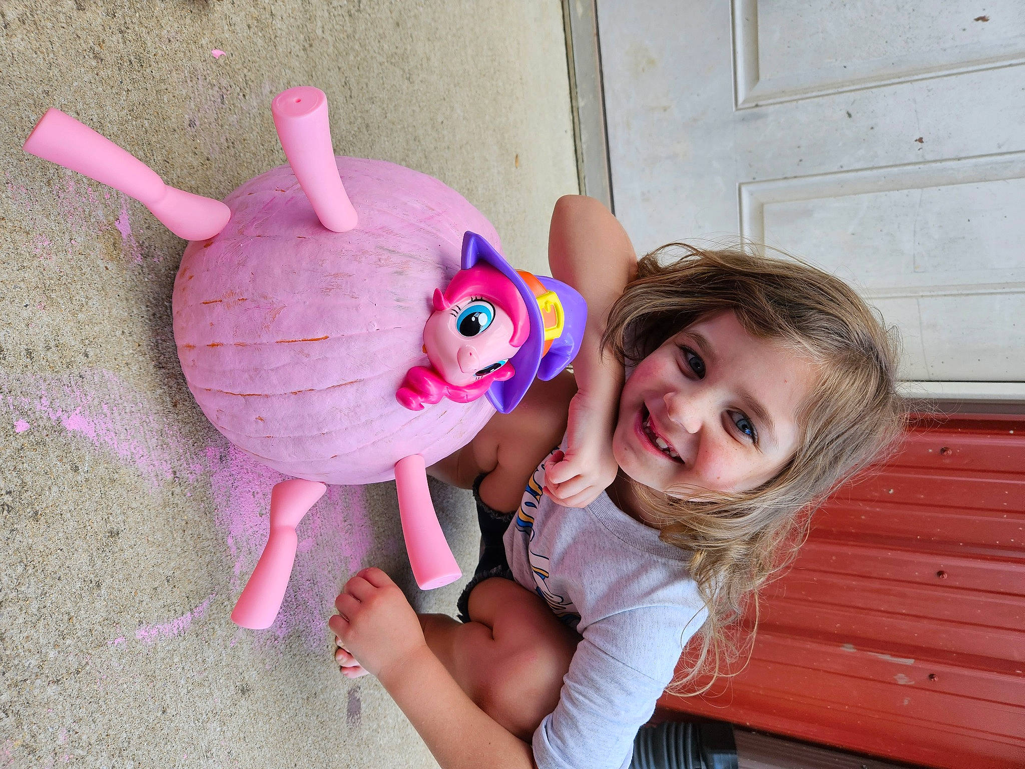 Charlee is registered to the contest to win money with this photo: baby_toddler_clothing, child, door, facial_expression, gesture, happy, head, joy, magenta, person, pink, purple, skin, smile, stuffed_toy, tail, thumb, toddler, toy, violet