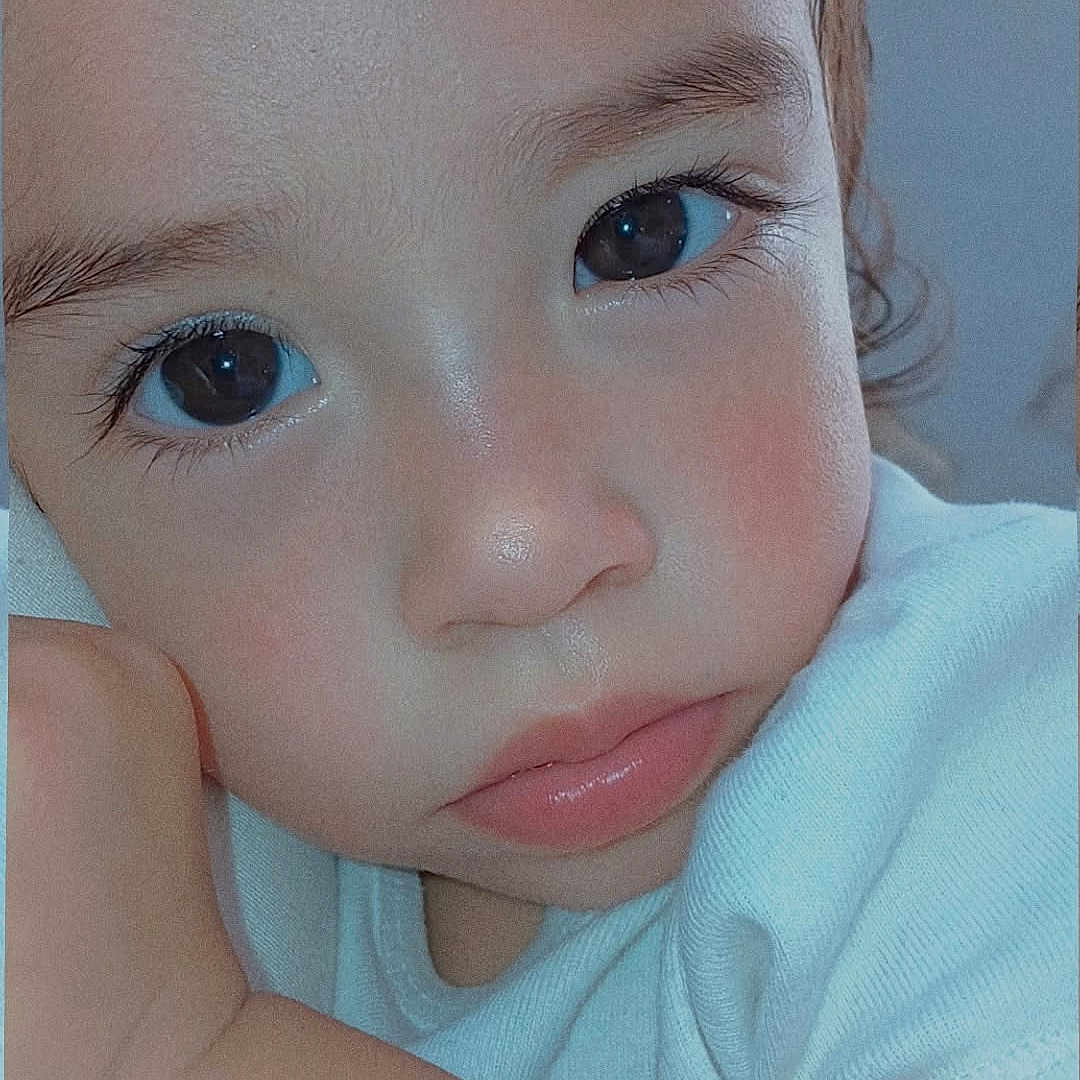 Emily is registered to the contest to win money with this photo: child, close_up, portrait, face, eyes, expression, skin, white_shirt, arm, resting, young, indoors, cute, pensive, soft_lighting, person, human, baby, toddler, head