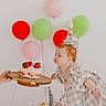 Eloise is registered to the contest to win money with this photo: toddler, birthday, cake, party_hat, balloons, strawberries, plush_toys, celebration, child, dress, candle, hand, pink, red, green, indoor, cute, fun, happy, toy