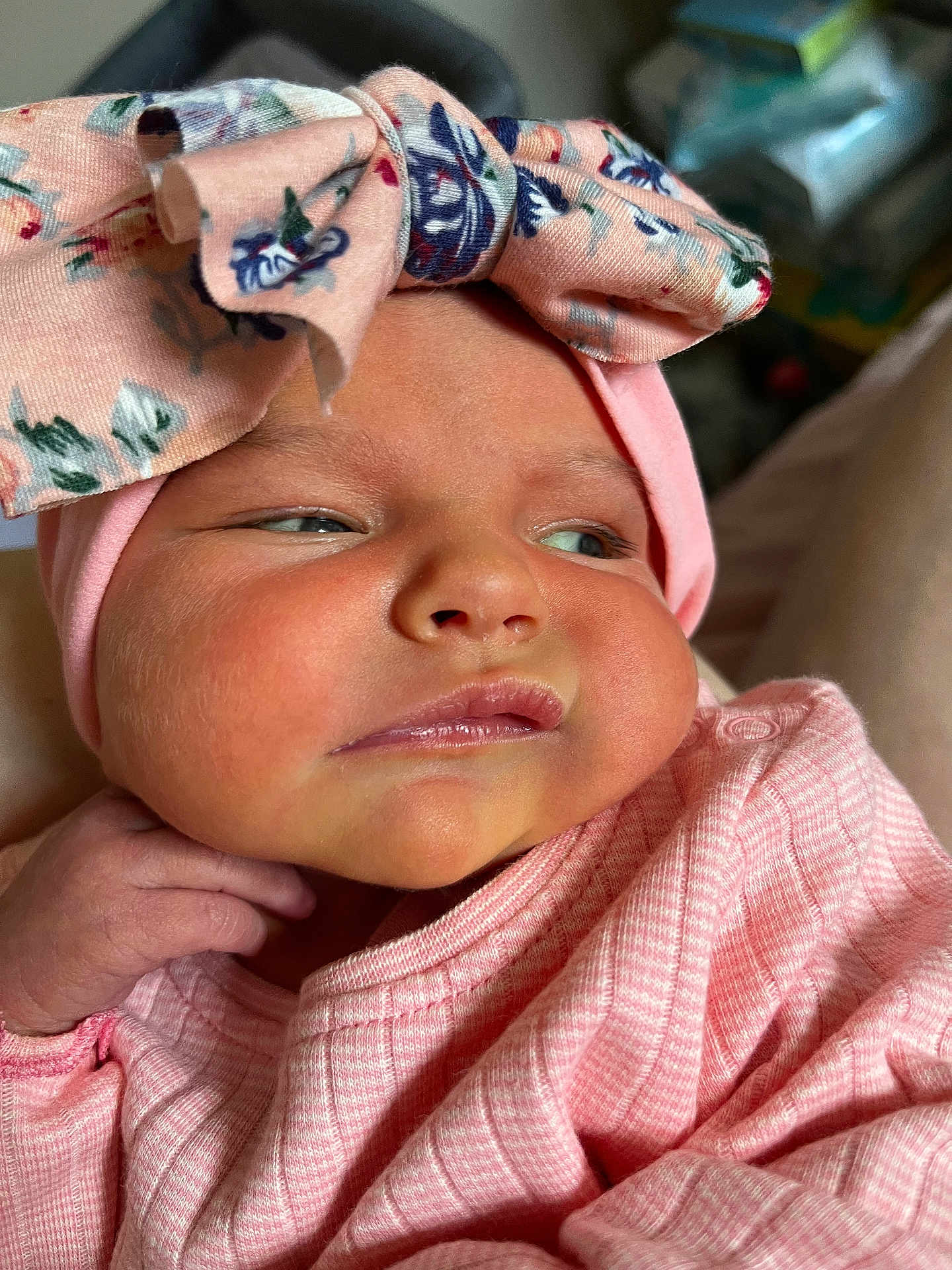 Ava-Rose is registered to the contest to win money with this photo: baby, infant, face, headband, bow, pink_clothing, closeup, skin, cheeks, expression, newborn, hand, portrait, cute, child, person, apparel, soft_lighting, indoors, fabric