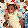 baby, baseball, basketball, blanket, cap, clothing, cute, glove, indoors, infant, newborn, pacifier, pattern, peaceful, resting, sleeping, soccer_ball, soft, sports, toddler