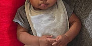 Braxton is registered to the contest to win money with this photo: baby, bear_print, beige_pants, bib, child, comfortable, couch, curly_hair, cute, expression, gray_clothing, hands, home, indoor, infant, pillow, portrait, seated, soft_lighting, tongue_out