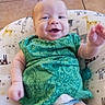 baby, baby_girl_or_boy, child, comfortable, cushion, cute, diaper, dinosaur_pattern, giraffe_pattern, green_clothing, happy, indoor, infant, one_person, playful, portrait, reaching_hand, smiling, tile_floor, young_child