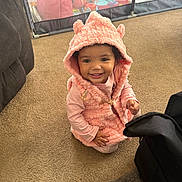 Braelynn joined the competition — help win amazing prizes! toddler, child, smile, pink_clothing, hooded_vest, carpet, indoor, playpen, toys, happy, person, baby, candid, cute, floor, young_child, warm_clothing, home, black_bag, casual
